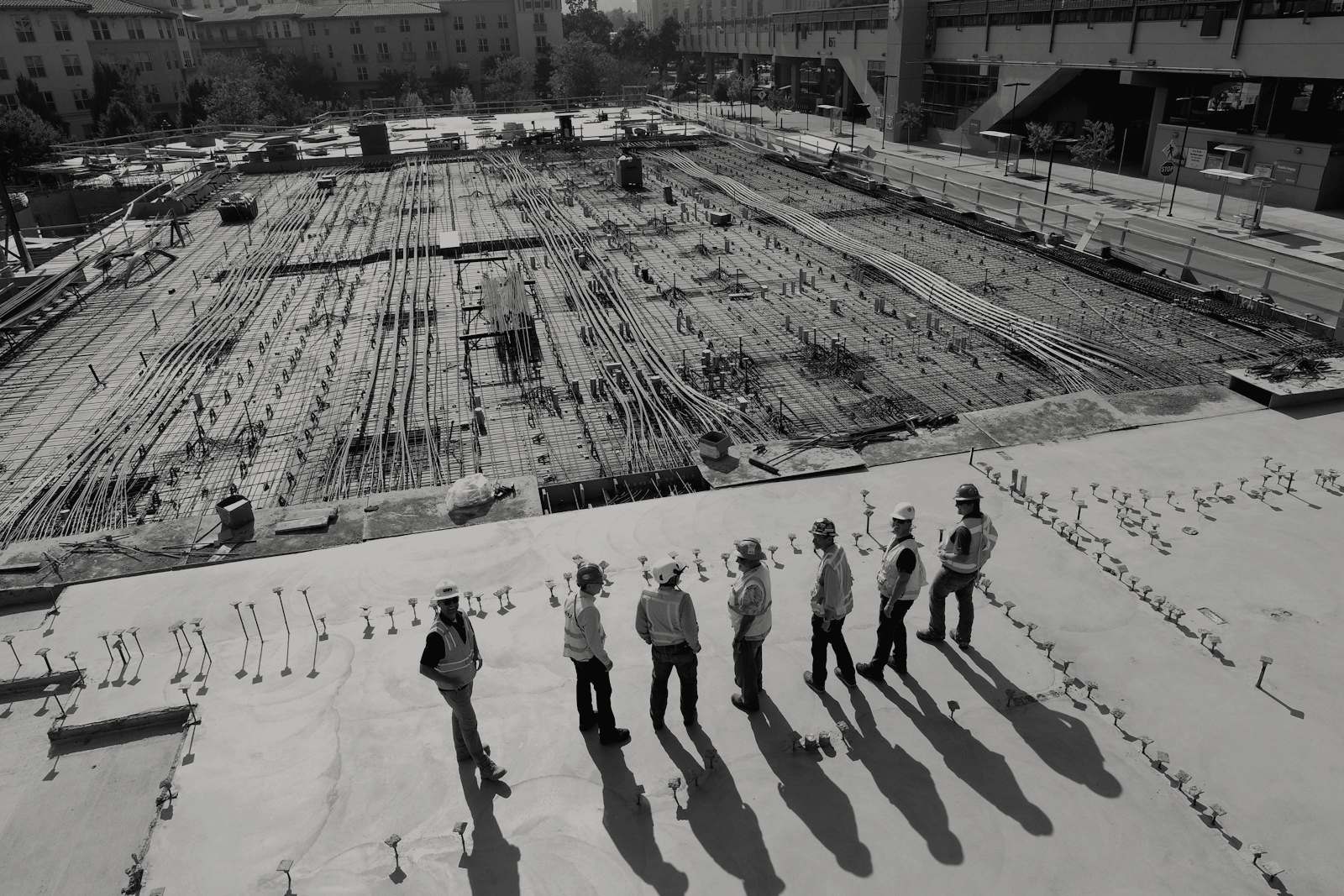 Aerial view of a building foundation being laid — a rebar grid before anything stands on it